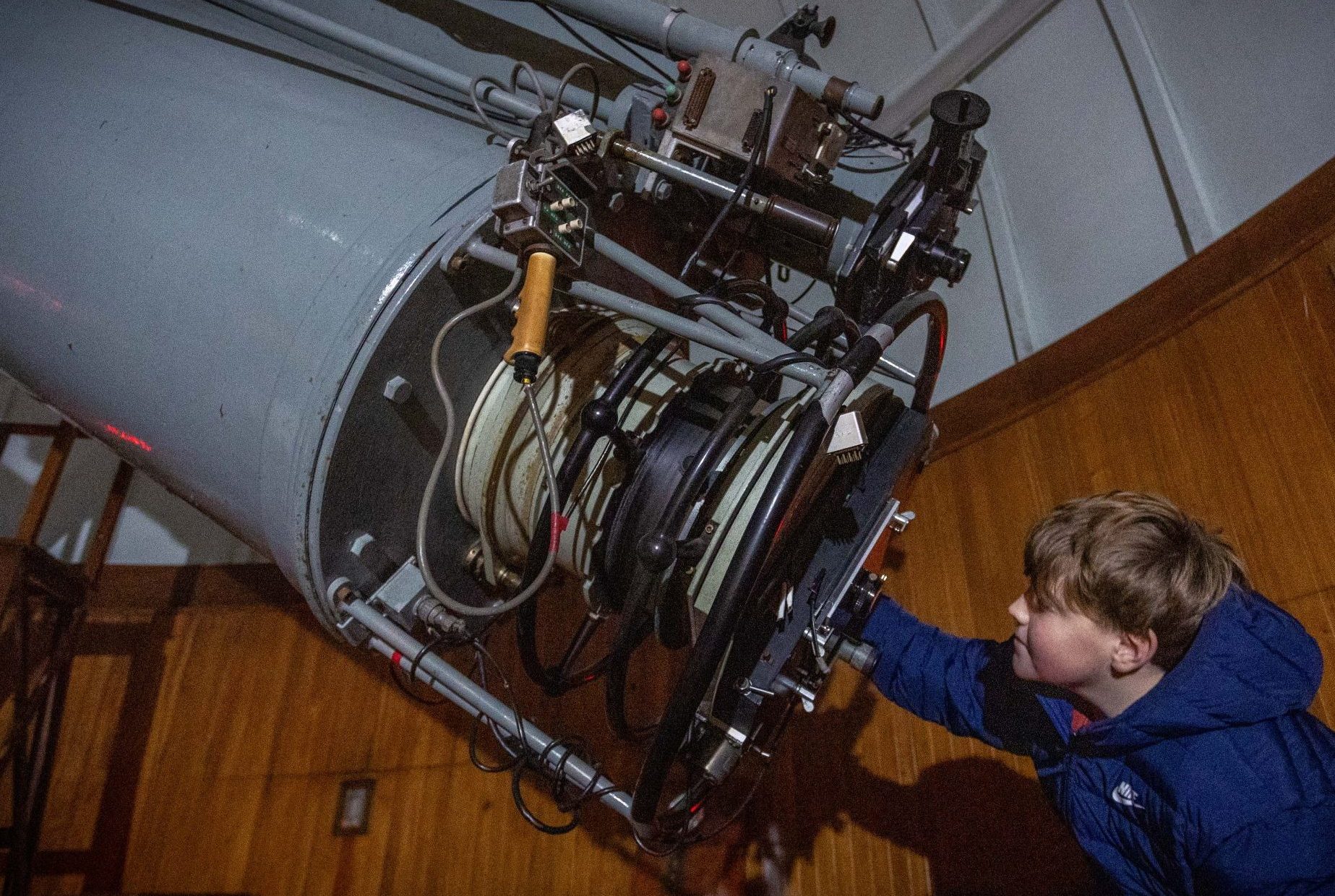 Boy looking through an historic telescope