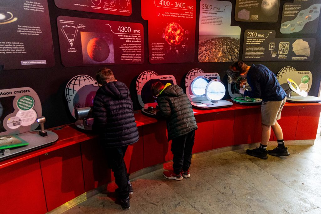children at the Observatory playing with hands on space exhibits