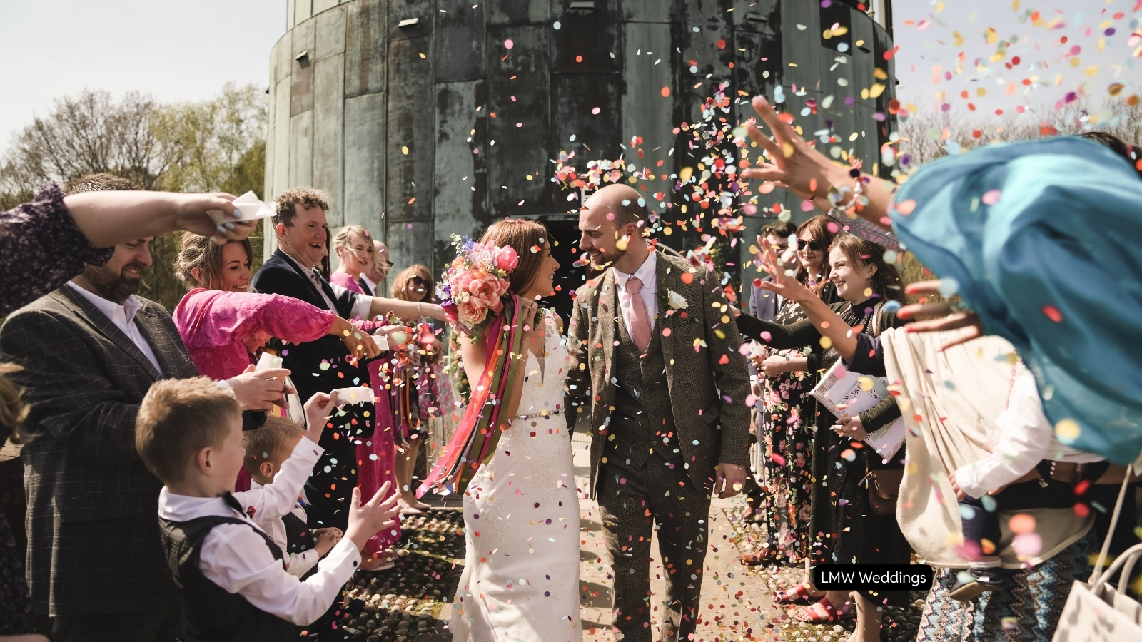 Bride and groom with guests throwing confetti, photo by LMW weddings