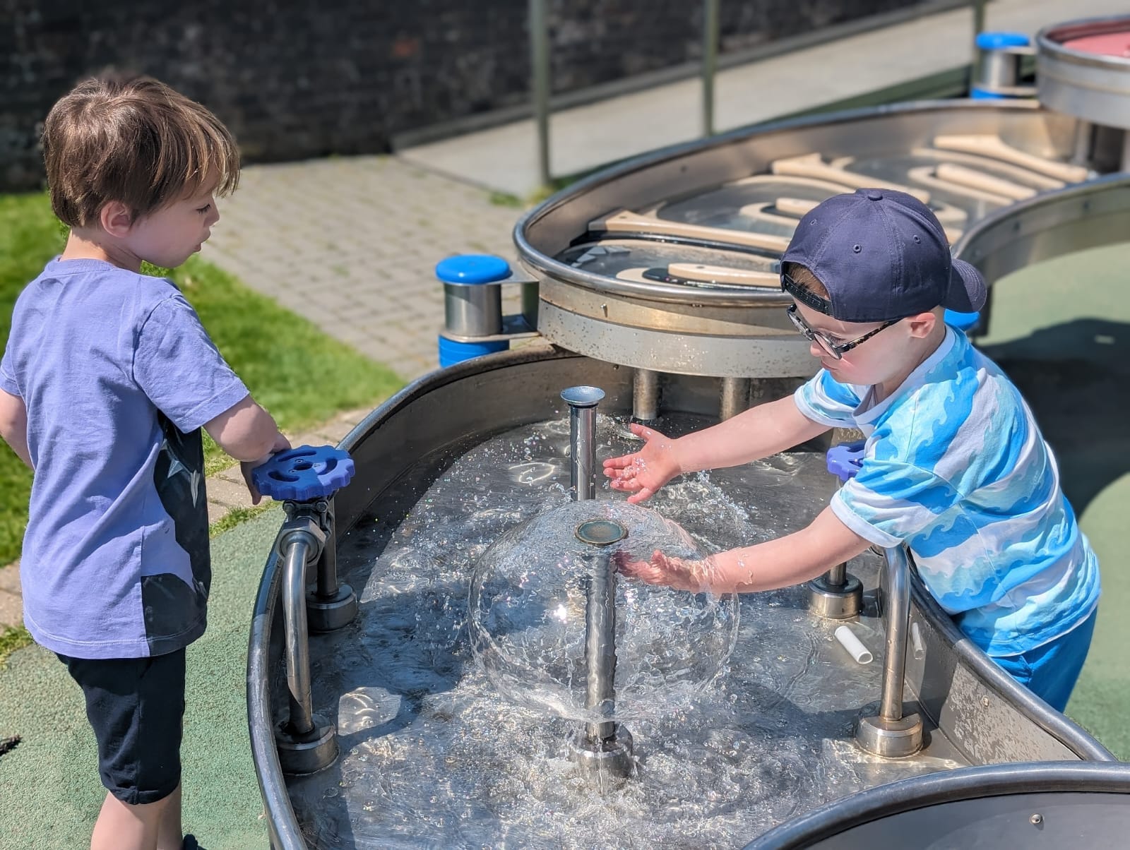 Two boys playing with a water exhibit at the Observatory Science Centre & Museum